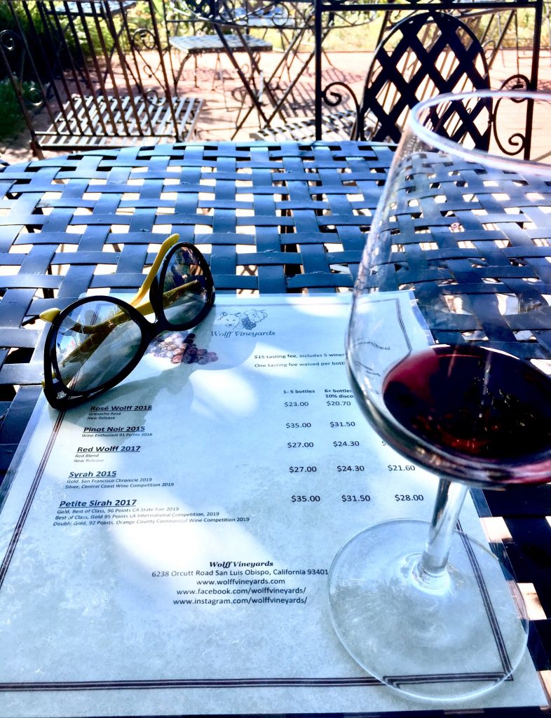 Outdoor seating with some red wine and the menu